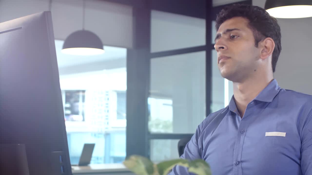 trabajado, cansado y agotado joven empleado de oficina se quita las gafas sentado frente a la computadora