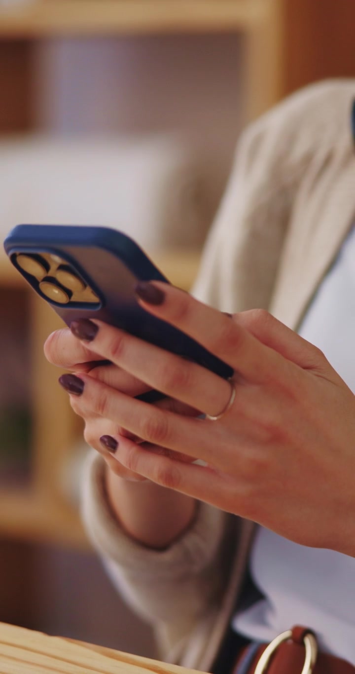 Primo piano di una donna che usa uno smartphone in ufficio