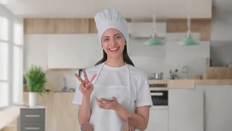 Happy-Indian-female-professional-chef-noting-down-recipe