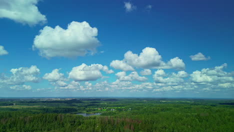 Eine-Sanfte-Aufnahme-Einer-Grünen-Graslandschaft-Mit-Wäldern-Und-Einem-Teich-Neben-Einem-Kleinen-Dorf