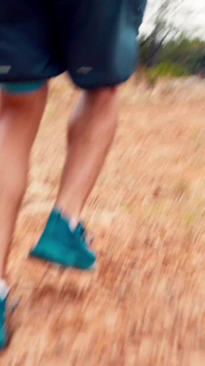 Primo piano delle gambe di un runner su un sentiero sterrato