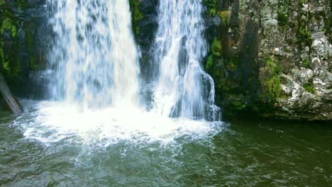 cascada que llega a un lago. imágenes de drones, movimiento vertical