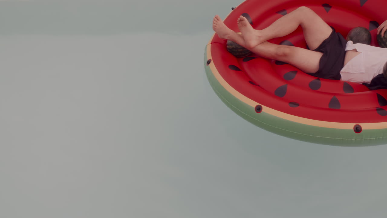 Man Relaxing on Watermelon Inflatable Pool Float