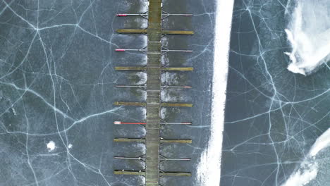 empty wooden jetty and marina at vik bathavn with crack ice at steinsfjorden in norway