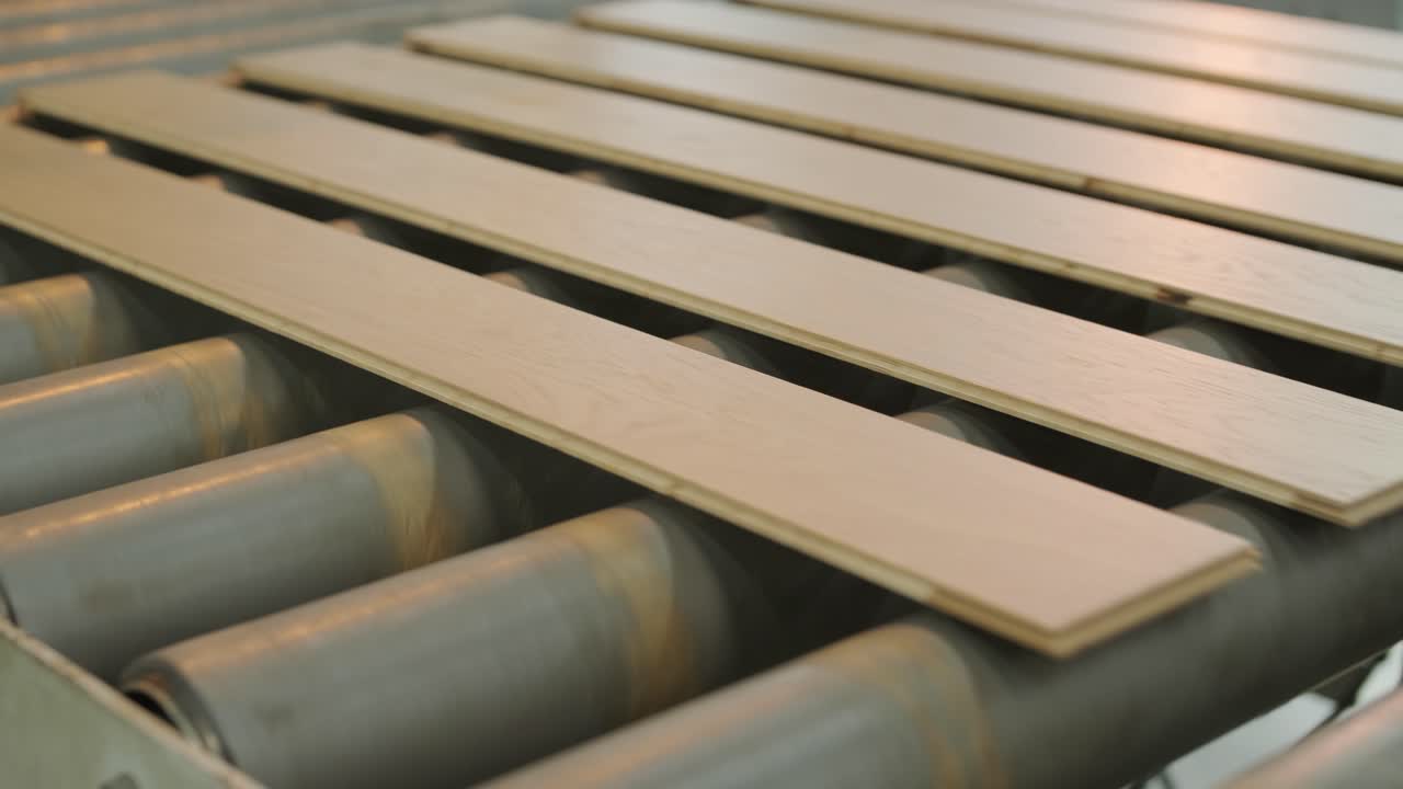 Assi di legno in movimento su un nastro trasportatore a rulli in una fabbrica