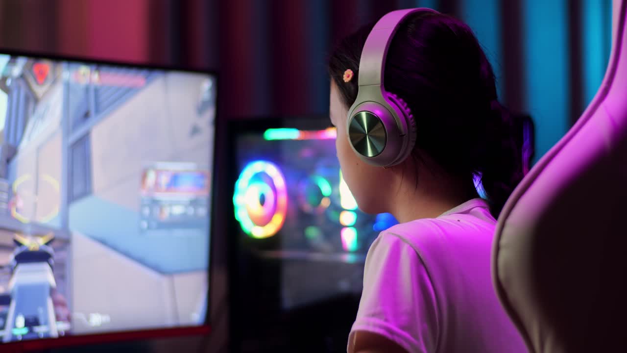 Primo piano di una ragazza gamer adolescente asiatica che perde mentre gioca a un videogioco al computer, videogioco sparatutto online
