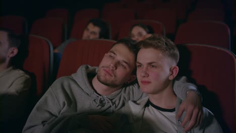Couple-gays-embracing-in-movie-theater.-Homosexual-men-embrace-in-movie-theatre