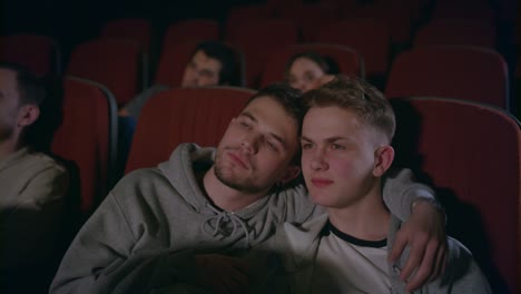 pareja de gays abrazándose en el cine. hombres homosexuales abrazándose en el cine