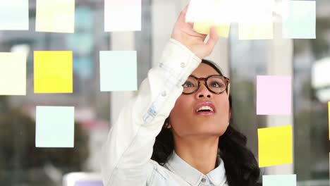 mujer de negocios asiática mirando notas adhesivas
