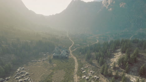 mysterious abandoned house surrounded by mountains and winding path in nature