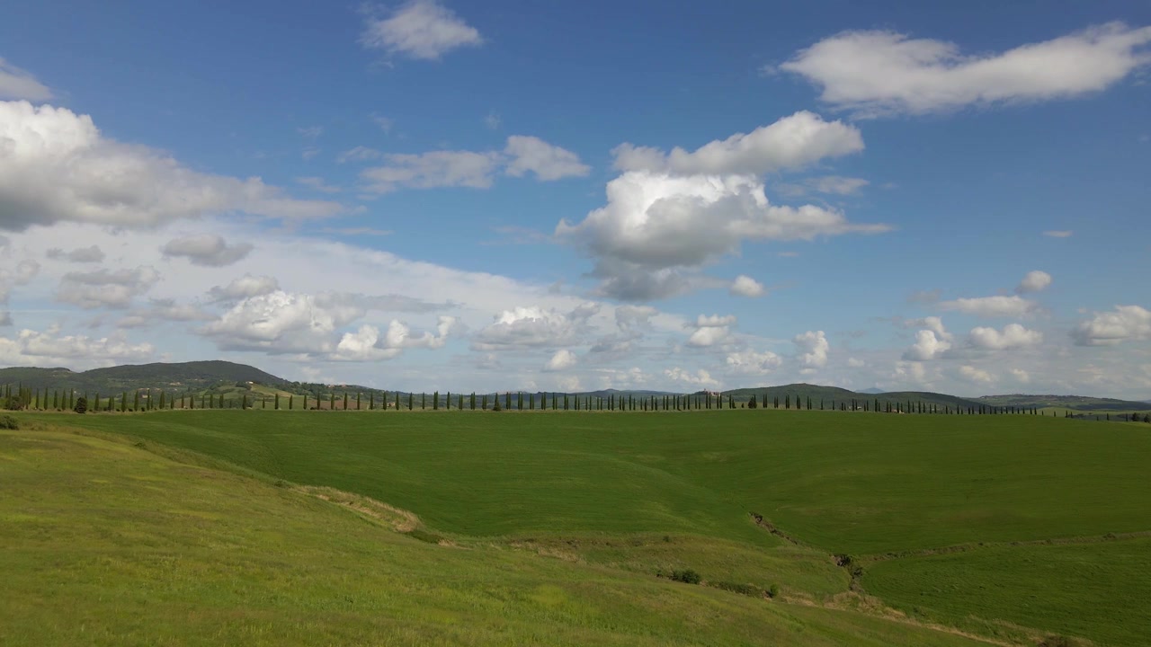 Betagende luftfoto af bølgende grønne bakker og cypresser i Toscana, Italien. Perfekt til rejse-, wellness- og bæredygtighedstemaer.
