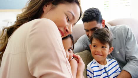 familia feliz sentada en el sofá y abrazada en la sala de estar