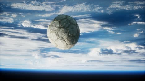 old soccer ball in space on earth orbit