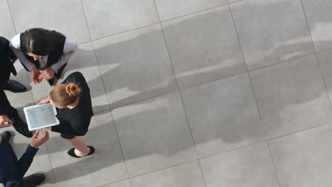 top view of group of workers in stylish clothes talking in hall of office building