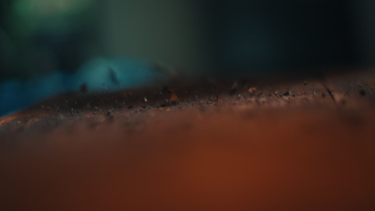Primissimo piano della texture di una superficie metallica su un banco da lavoro dell'officina, trucioli di limatura che rimbalzano ad ogni colpo di martello, astratto