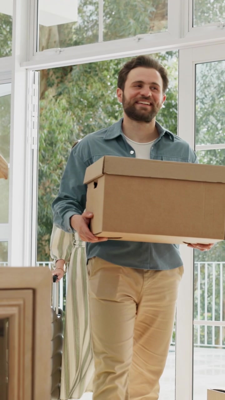Couple Arriving at New Home with Moving Boxes and Luggage