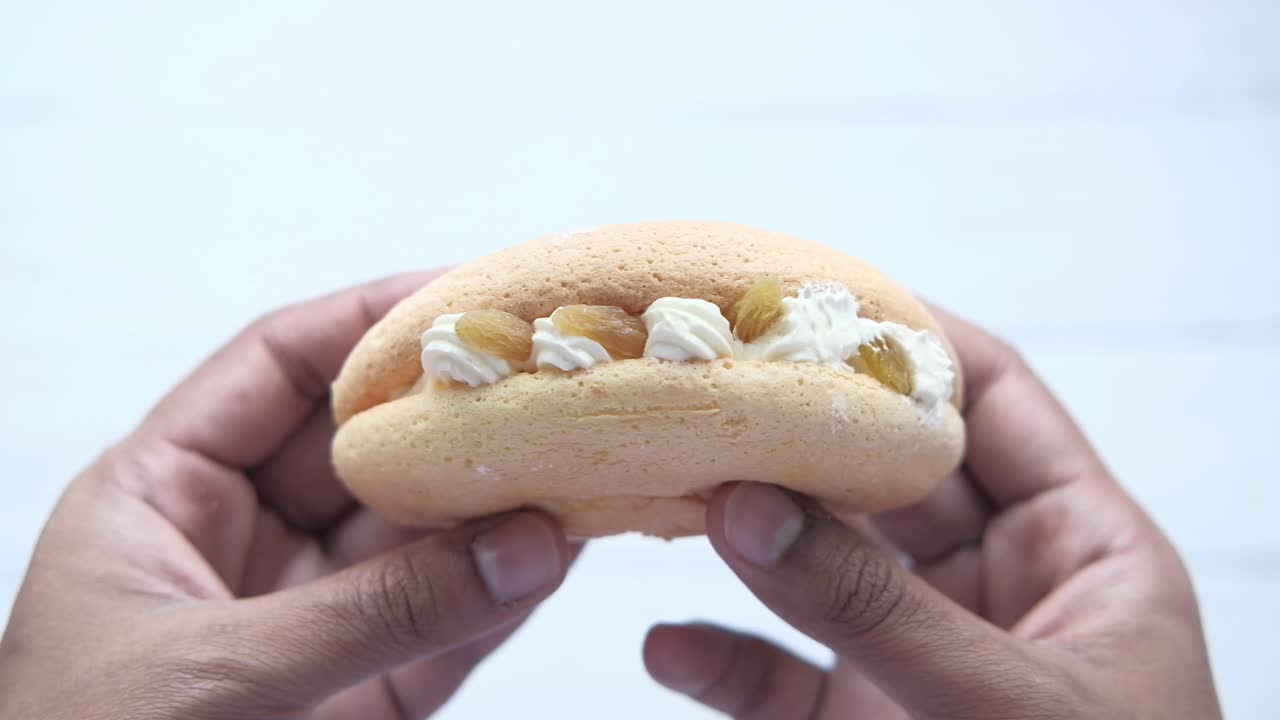 손에 들고 있는 크림으로 가득 찬 마카론