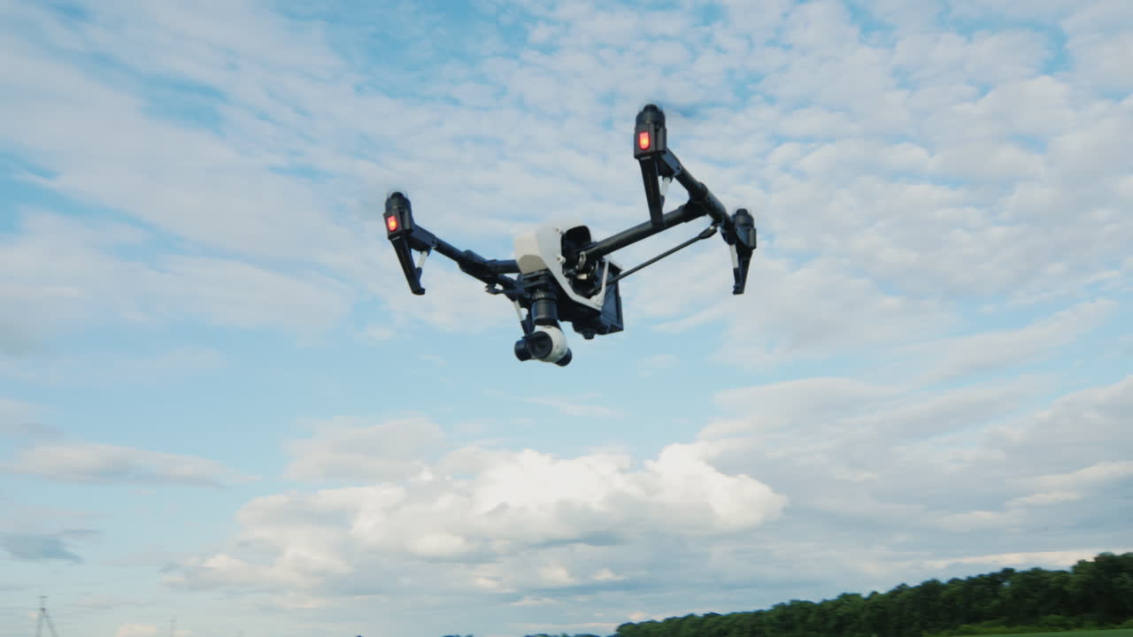 헬리콥터 또는 드론이 푸른 하늘을 배경으로 날아갑니다.