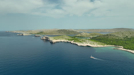 una toma de un avión no tripulado de un yate que navega junto a la isla en el parque nacional de kornati