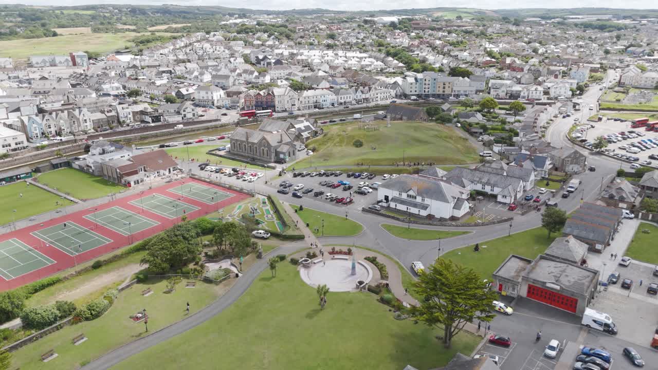 Aerial View of a Coastal Town with Residential Buildings, Park, and Tennis Courts