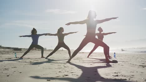 Gruppe-Verschiedener-Freundinnen,-Die-Yoga-Am-Strand-Praktizieren