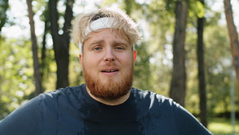 portrait of exhausted obese man after run in park