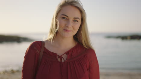 portrait of beautiful young blonde woman on beach smiling cheerful runs hand through hair feeling confident