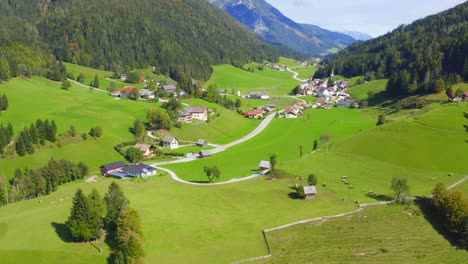 a drone shot of a small town with houses and a valley at, austria