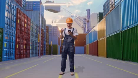 cuerpo lleno de hombre asiático trabajador con gafas de protección y casco de seguridad mirando su teléfono inteligente, sonriendo, y diciendo wow mientras estaba de pie en el almacén del patio de contenedores