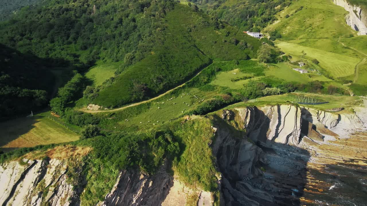 el avión no tripulado se eleva y se retira para revelar toda la playa de sakoneta en españa, al mediodía cálido