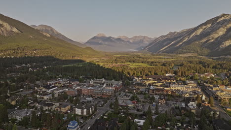 banff ab canada aerial v23 flyover town center and bow river capturing residential houses, horse stables and sunlight on forested valley and mountain ranges - shot with mavic 3 pro cine - july 2023