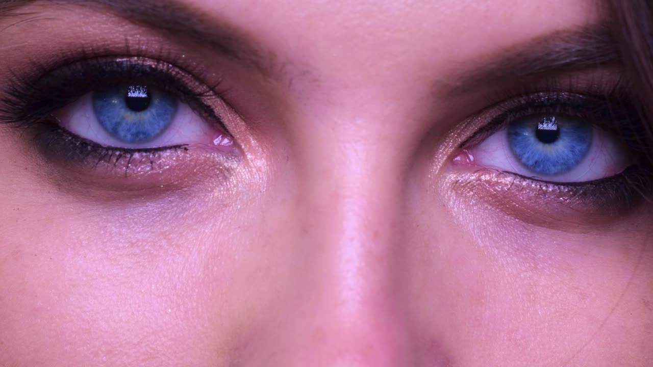 A Close-Up Examination of Striking Blue Eyes: The Beauty of Eye Makeup and Expression Captured in Two Frames