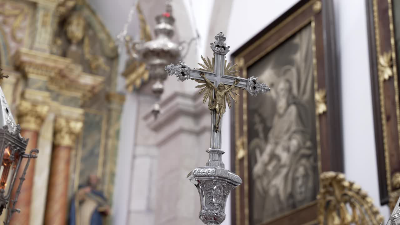 close up of ornate silver crucifix with radiant gold accent inside church