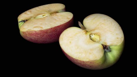 Close-up-shot-of-rotting-fresh-apple-on-black-surface,time-lapse