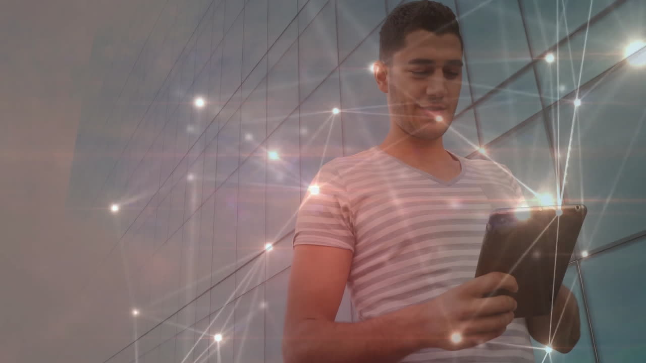Man holding tablet near reflective glass facade, with digital network nodes connecting around him