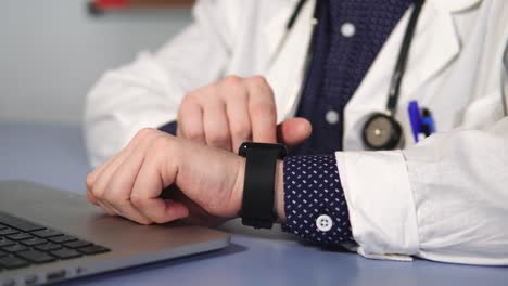 médico usando reloj inteligente en la oficina