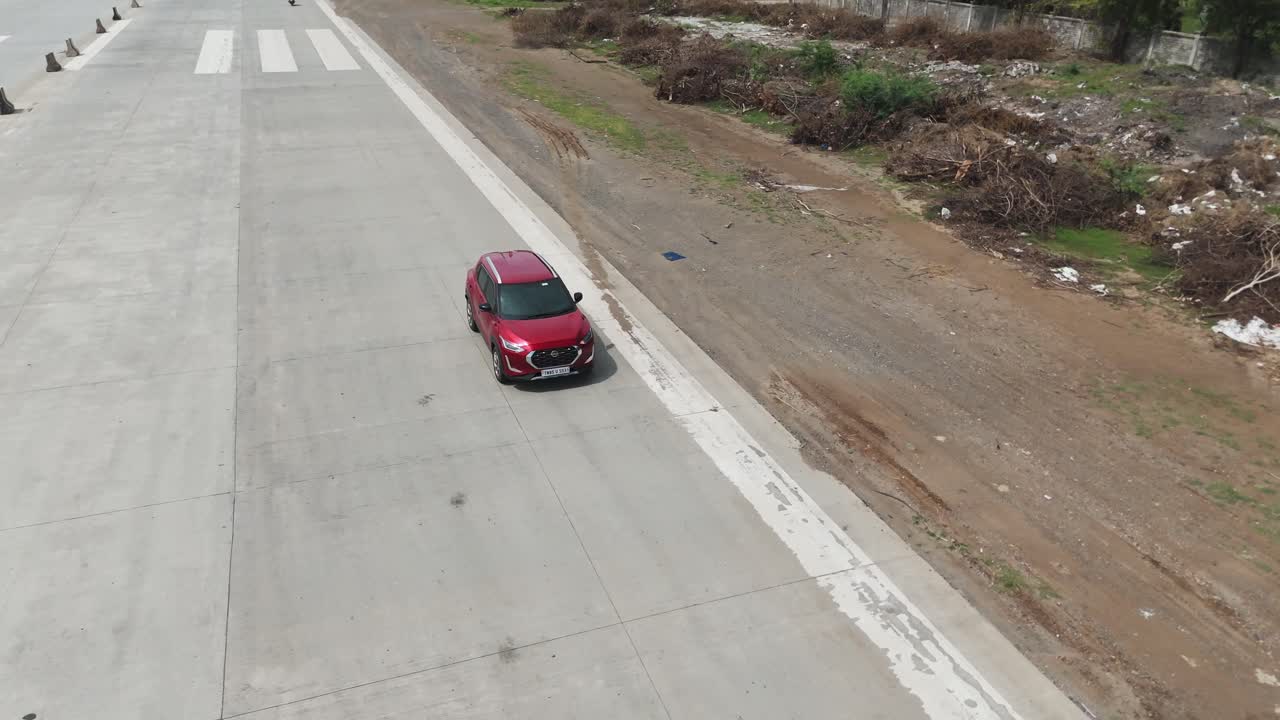 A cinematic aerial shot captures a car bustling in a highway emergency landing runway constructed on NH 16 Chennai-Vijayawada expressway