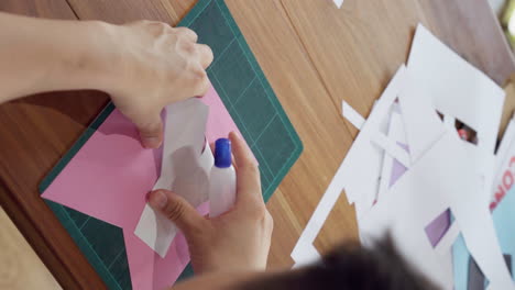 hombre asiático haciendo un proyecto de artesanía diy pegando letras del alfabeto a una bandera