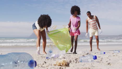 Animation-of-cancer-over-diverse-female-and-male-volunteers-picking-up-rubbish-on-beach