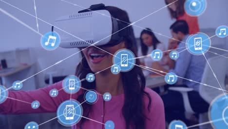 Animation-of-network-of-connections-with-icons-over-diverse-business-people-using-vr-headset