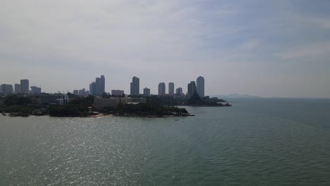 imágenes aéreas deslizándose hacia la derecha de las playas y el santuario de la verdad silueteado con edificios en el fondo, pattaya, chonburi, tailandia