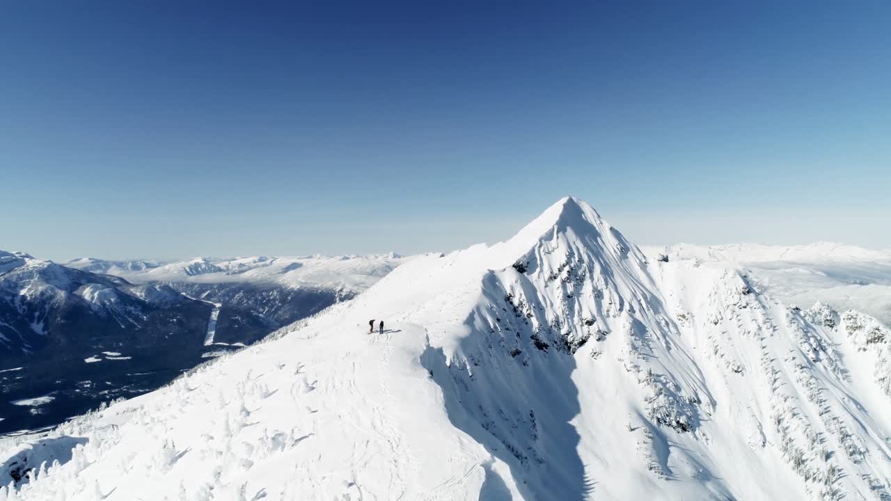 esquiadores de pie en una montaña cubierta de nieve 4k