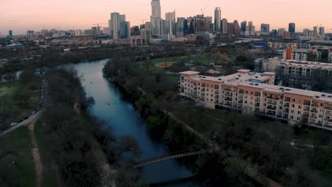 downtown austin texas skyline and ladybird lake at sunset, aerial drone pull away in 4k