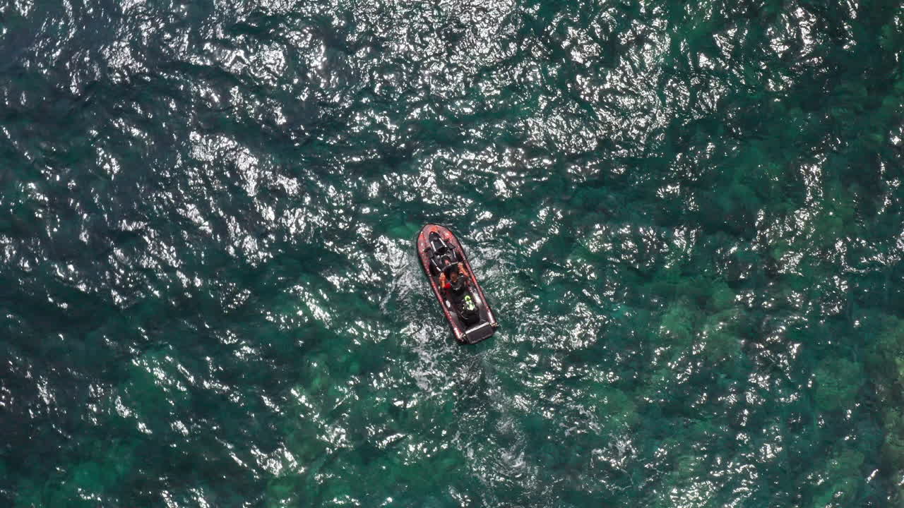 A boat sailing on the clear turquoise waters of sardinia, aerial view