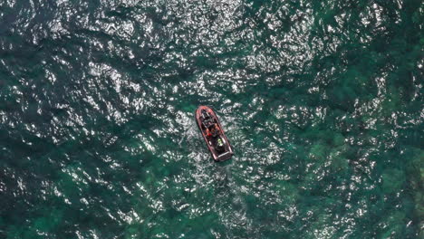 A-boat-sailing-on-the-clear-turquoise-waters-of-sardinia,-aerial-view