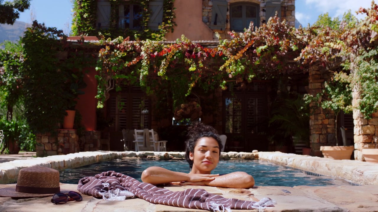 Mulher Jovem Relaxando em uma Piscina em uma Vila Mediterrânea