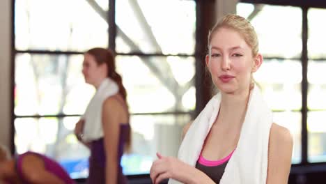 fit woman smiling at camera in gym