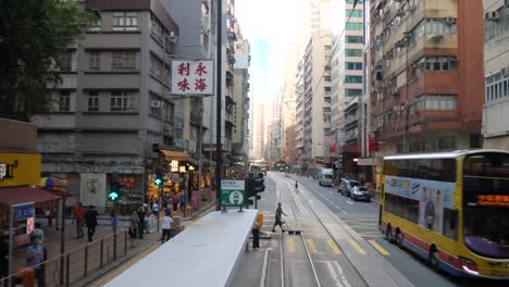 hong kong city street with trams and double-decker buses