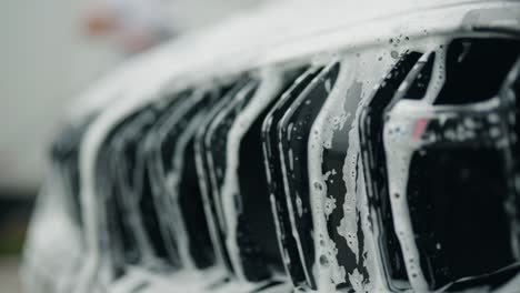 soap-and-water-falls-between-twin-kidney-grille-of-a-car-forming-an-interesting-little-cascade-with-reflections