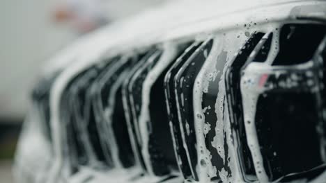 soap and water falls between twin kidney grille of a car forming an interesting little cascade with reflections